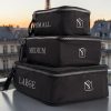 Cubes de rangement valise noirs vus de profil, doubles fermetures éclair et logo MOONLAC, sur un balcon parisien, MOONLAC chez Atelier Julac