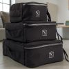 ubes de rangement valise noirs vus de l'arrière, empilés avec poignées et logo MOONLAC, dans un intérieur lumineux, MOONLAC chez Atelier Julac