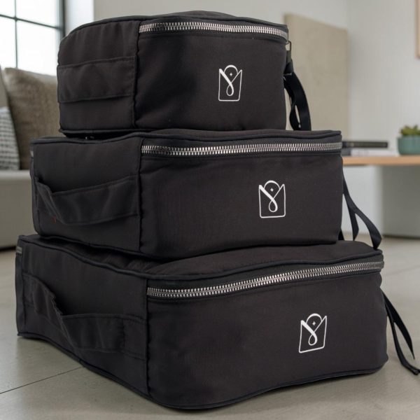 ubes de rangement valise noirs vus de l'arrière, empilés avec poignées et logo MOONLAC, dans un intérieur lumineux, MOONLAC chez Atelier Julac
