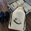 Sac à chaussures homme Été en coton écru ac à chaussures homme en coton écru imprimé mocassins, cordon noir, à côté d'une valise ouverte, MOONLAC chez Atelier Julac