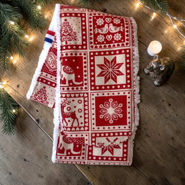 Bandeau de soins visage Noël rouge nordique rennes étoiles Bandeau de soins visage Noël rouge motif nordique avec étoiles, rennes et sapins, posé sur du bois avec branches de sapin et guirlande lumineuse, cousu main en France par Atelier Julac
