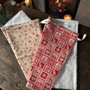 Essuie-mains éponge Noël Atelier Julac en coton imprimé chalet de montagne Noël rouge et écru, avec petit ruban d'accroche