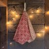 Essuie-mains éponge coton imprimé Noël motifs chalet et flocons Essuie-mains éponge Atelier Julac en coton imprimé Noël, motif chalet rouge et motif flocons écru, suspendu à un crochet avec guirlande lumineuse