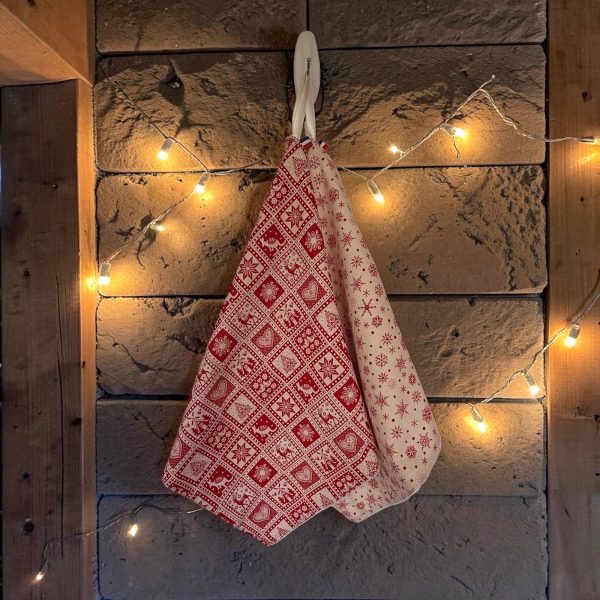 Essuie-mains éponge coton imprimé Noël motifs chalet et flocons Essuie-mains éponge Atelier Julac en coton imprimé Noël, motif chalet rouge et motif flocons écru, suspendu à un crochet avec guirlande lumineuse