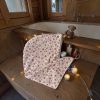 Serviette cheveux bambou Noël beige flocons de neige baignoire chalet Serviette cheveux en bambou Noël beige à flocons de neige rouges posée près d’une baignoire de chalet en bois, avec bougies, guirlande lumineuse et ourson, cousue main par Atelier Julac