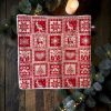 Serviette pour invités Noël montagne motifs scandinaves rouges Panière de serviettes pour invités Noël montagne, serviette en coton imprimé motifs scandinaves rouges, chalets, rennes et cœurs, avec ruban bleu blanc rouge - Atelier Julac